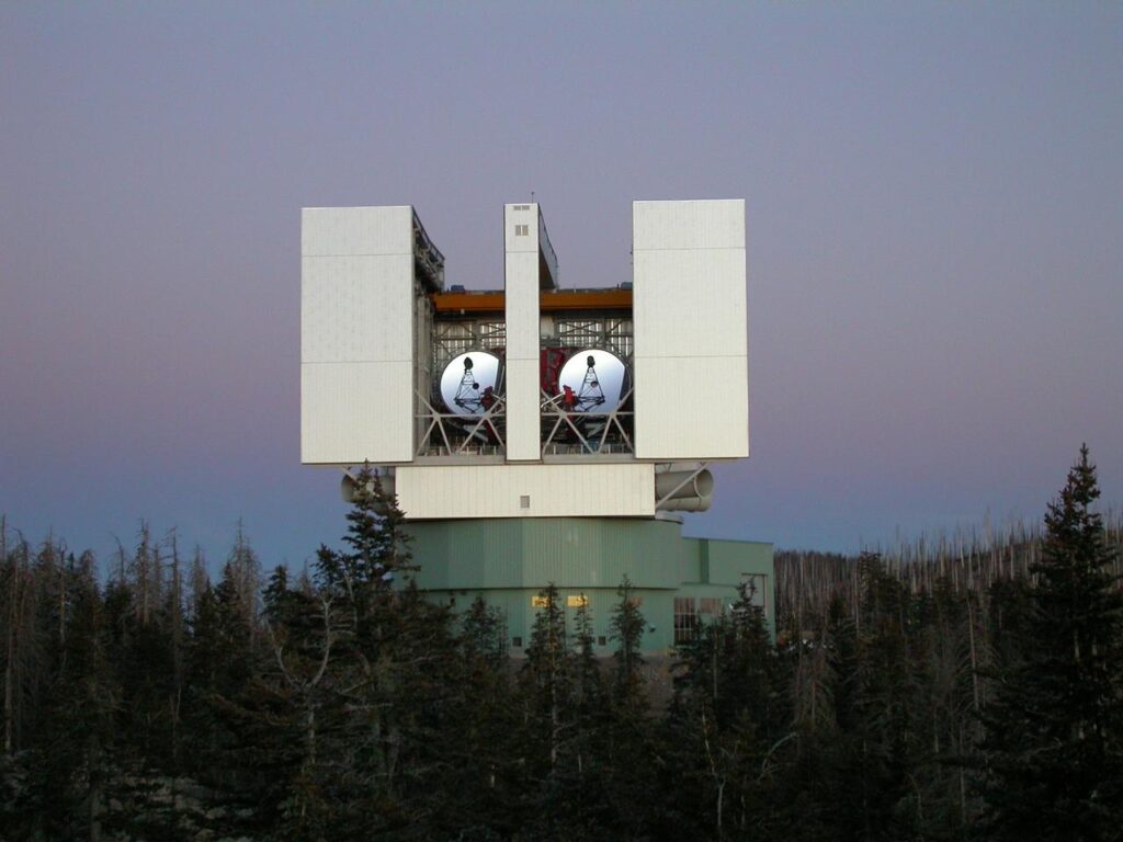 Mini-lunette astronomique posée dans l'herbe au crépuscule, sans personne visible