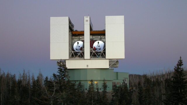 Mini-lunette astronomique pos\u00e9e dans l'herbe au cr\u00e9puscule, sans personne visible