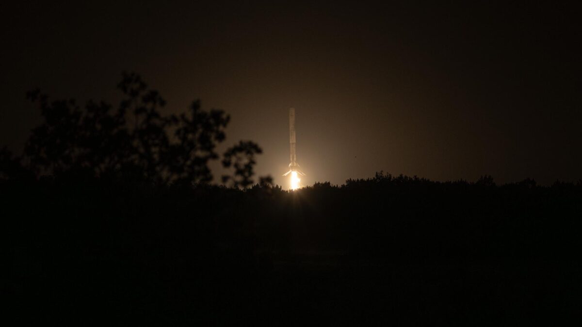 Premier \u00e9tage de Falcon 9 \u00e0 la verticale au moment de l'atterrissage, moteur central allum\u00e9