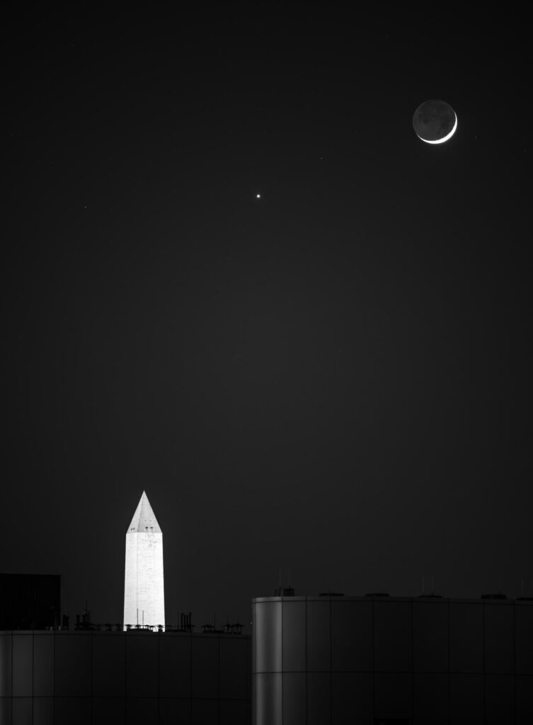 Conjonction entre un fin croissant de Lune et Vénus dans un ciel de crépuscule