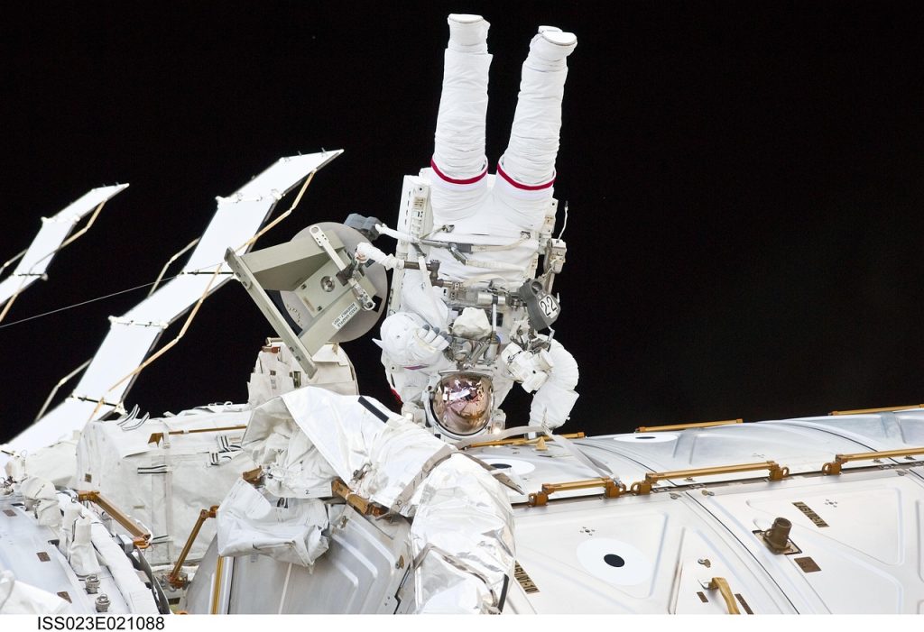 Astronaute en sortie extravéhiculaire près de la Station spatiale internationale