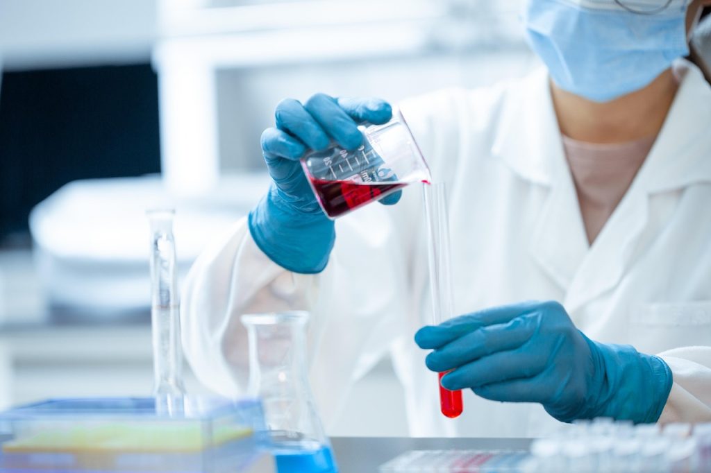 Scientifique manipulant un échantillon avec des gants de protection
