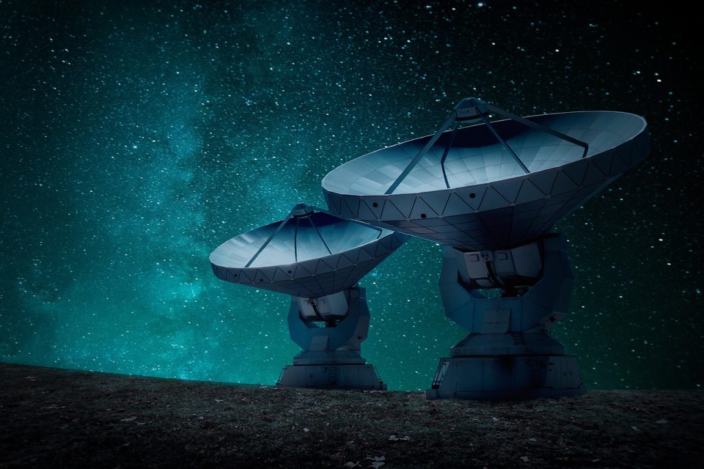 Antennes de radiotélescope pointées vers un ciel étoilé