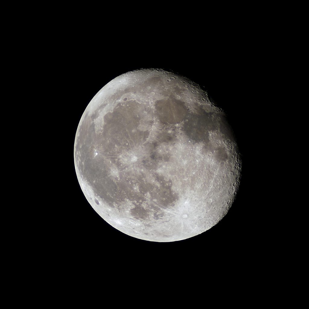 Surface lunaire marquée par un grand cratère sombre