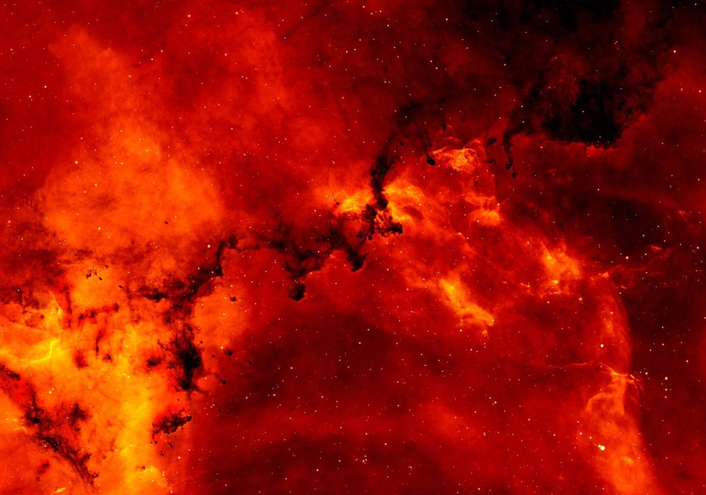 Nébuleuse lumineuse aux teintes rouges et oranges dans l'espace profond