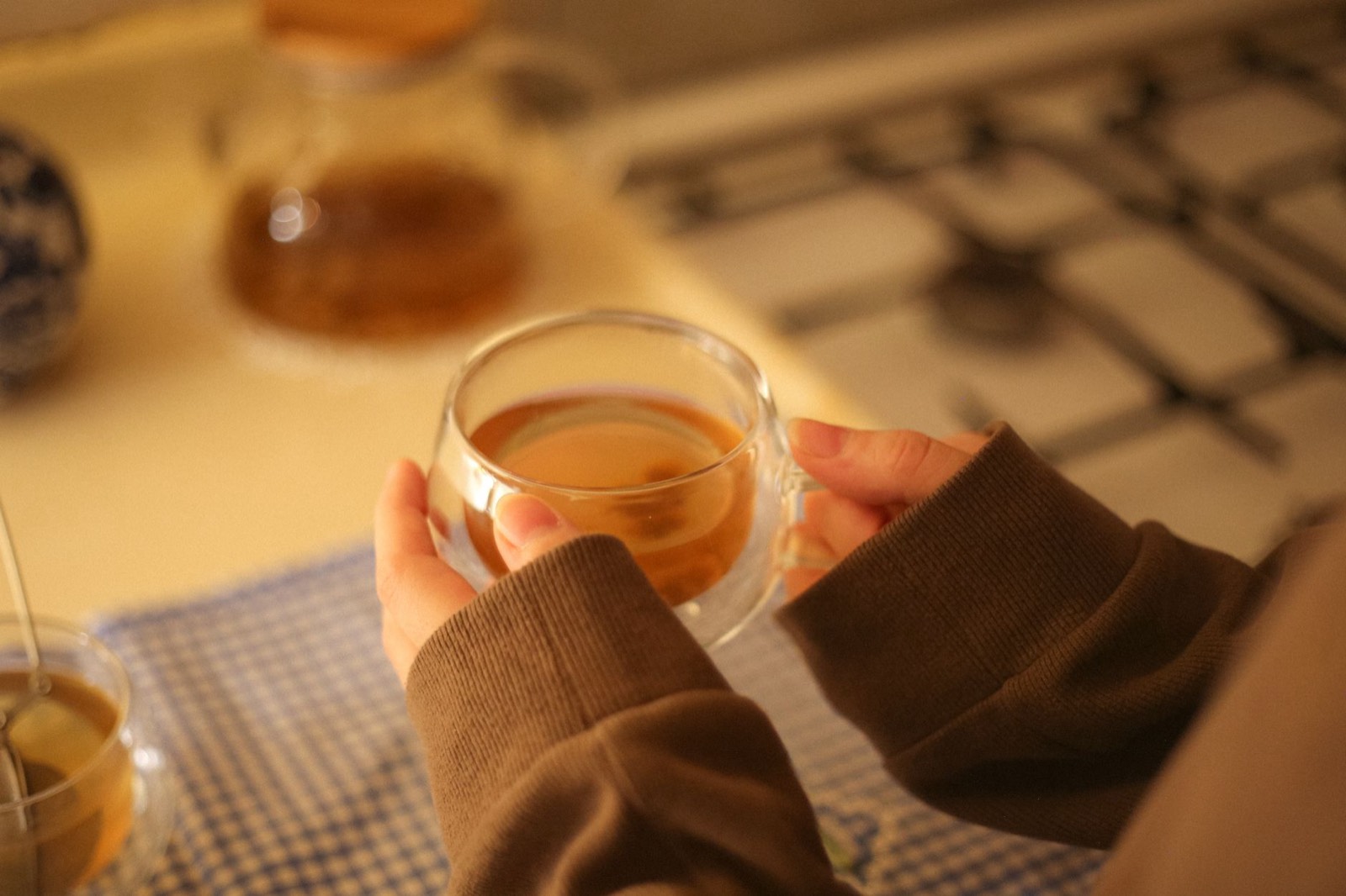 personne buvant une boisson le soir dans une cuisine