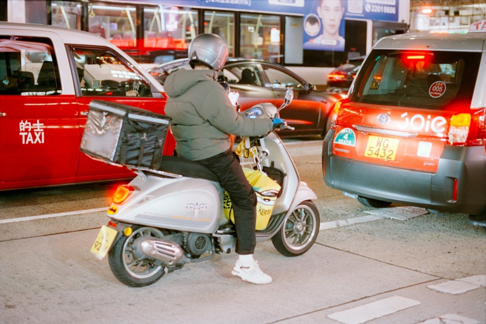 Scooter de livraison dans une rue éclairée la nuit