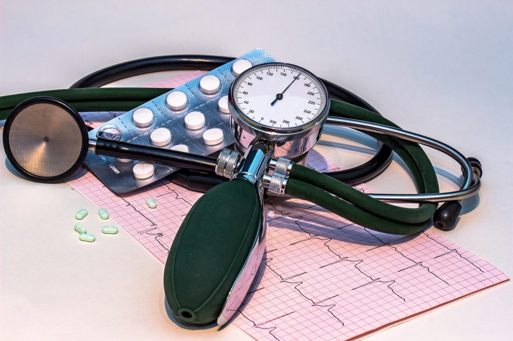 Stéthoscope et tensiomètre posés sur un électrocardiogramme