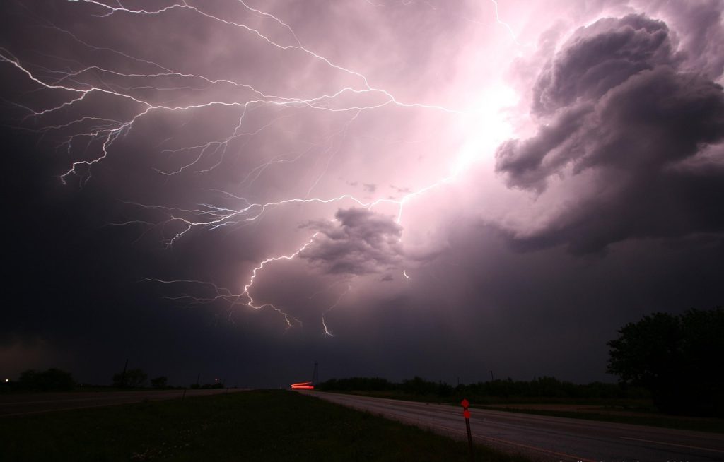 Éclairs et nuages d'orage au-dessus d'une route de campagne